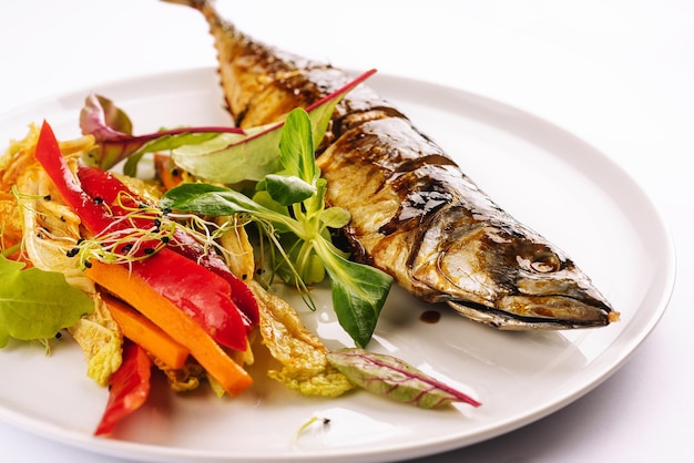 Baked mackerel with steamed vegetables on plate