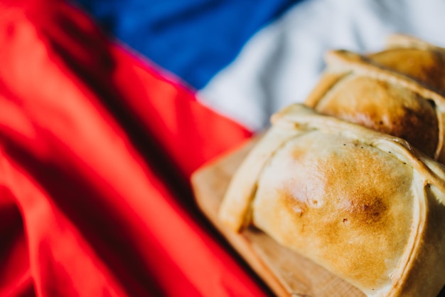 Baked meat chilean empanadas on the chilean flag. Copy space. Independence day. Selective focus