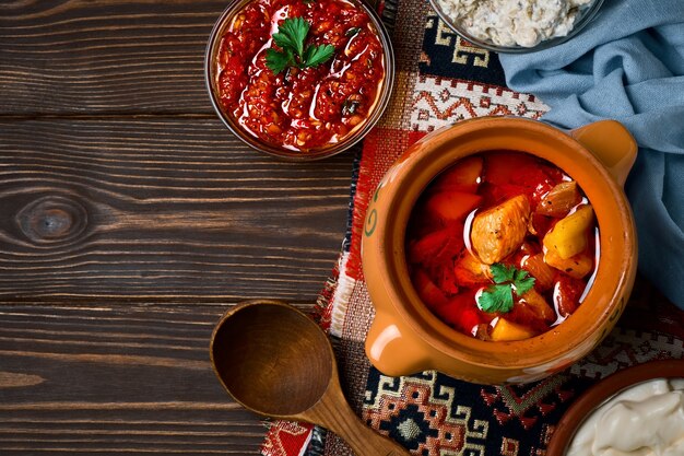 Baked meat in a clay pot, or a traditional pot dish, a stew with vegetables and meat cooked in the oven. turkish and balkan or oriental food platter, flat lay with copy space