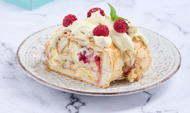 Baked meringue roll with cream and fresh red raspberry white backgroundx9