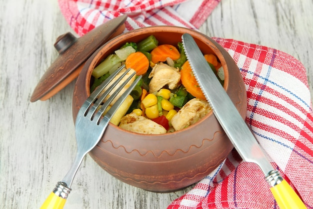 Baked mixed vegetable with chicken breast in pot on wooden background