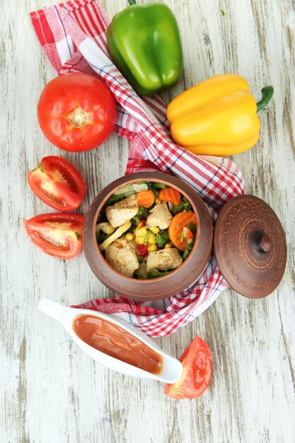 Baked mixed vegetable with chicken breast in pot on wooden background