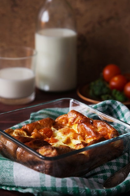 Baked omelet with tomatoes and bottle of milk