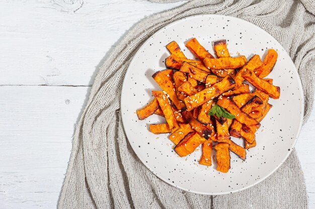 Baked organic batata fries with spices and sauce Sweet vegetable served portion and cutlery