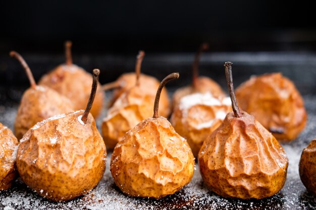 Baked pears on baking tray with sugar