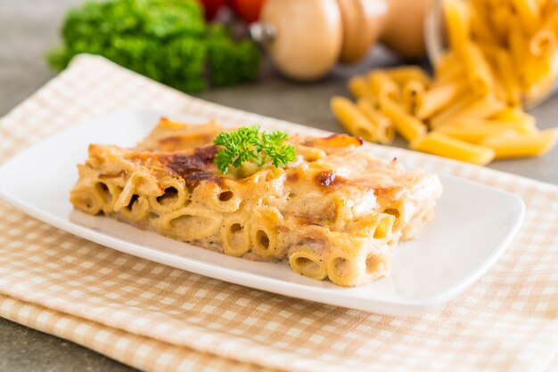 Foto pasta di penne al forno con formaggio e prosciutto