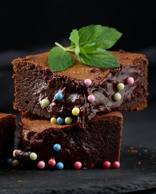 Baked pieces of chocolate brownie pie on a black table