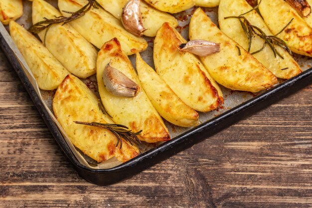 Baked pieces of spiced potato in a baking pan