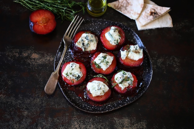 Baked plums with dor blue cheese on a plate