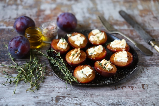 Baked plums with white cheese and herbs