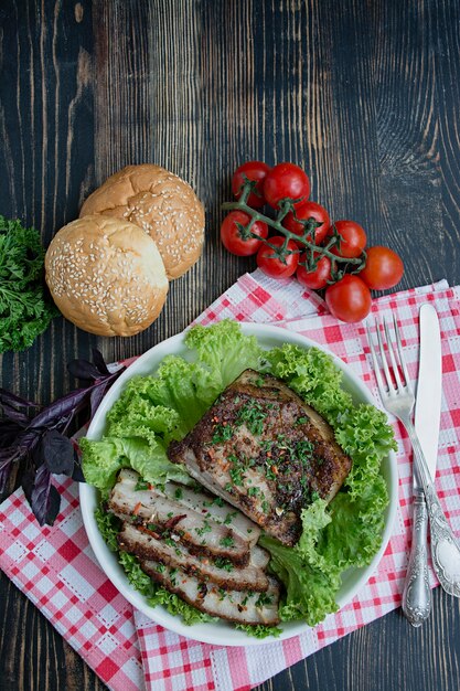 Baked pork belly with spices. Sliced breast, served with greens. Traditional dish of Ukraine.