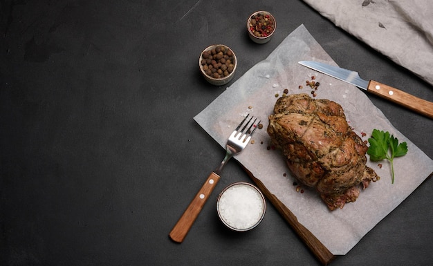 Baked pork collar with spices on a wooden board delicious and juicy meat