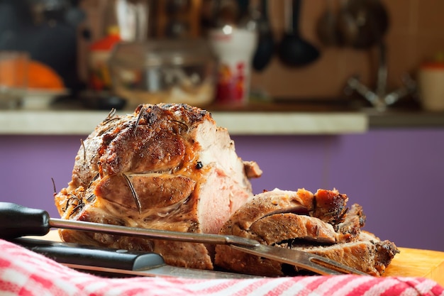 Baked pork meat with spices on brown wooden cutting board