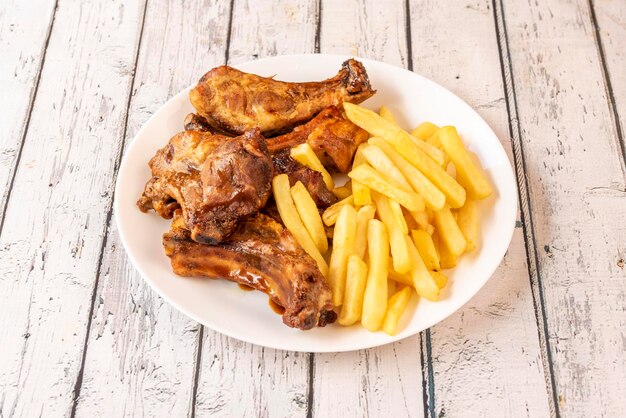 Baked pork ribs with barbecue sauce garnished with french fries
