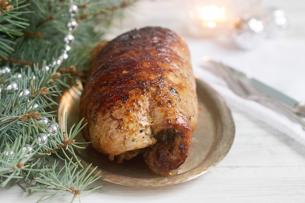 Baked pork roll stuffed with chard and sundried tomatoes in Christmas decorations.