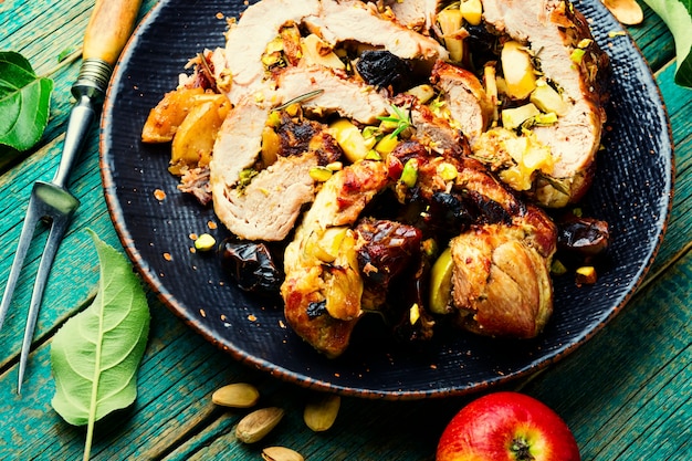 Baked pork with dates, apples and pistachios. Roasted lean pork.