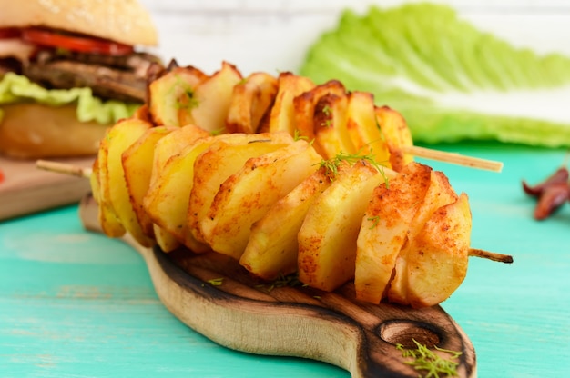 Baked potato circles on a bamboo skewer with spices