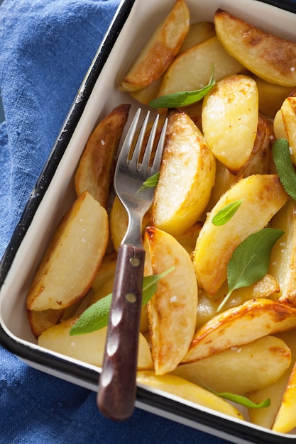 Photo baked potato wedges in enamel baking dish