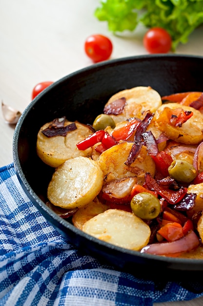 Baked potato with vegetables in a frying pan