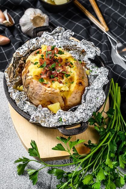 Baked potatoes with bacon, green onion and cheese.