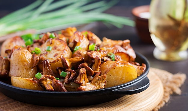 Baked potatoes with garlic, herbs and fried chanterelles in a cast iron skillet