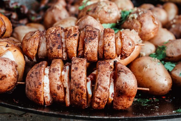 Baked potatoes with lard on a wooden skewer and red paprika