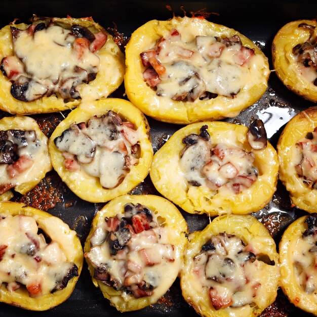 Baked potatoes with mushrooms, meat and cheese.