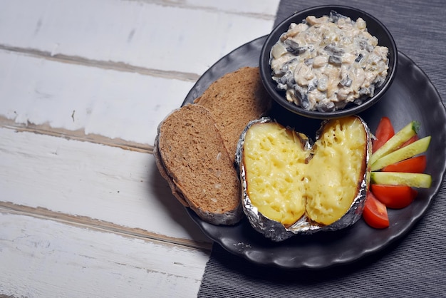 Baked potatoes with mushrooms and vegetables on a plate