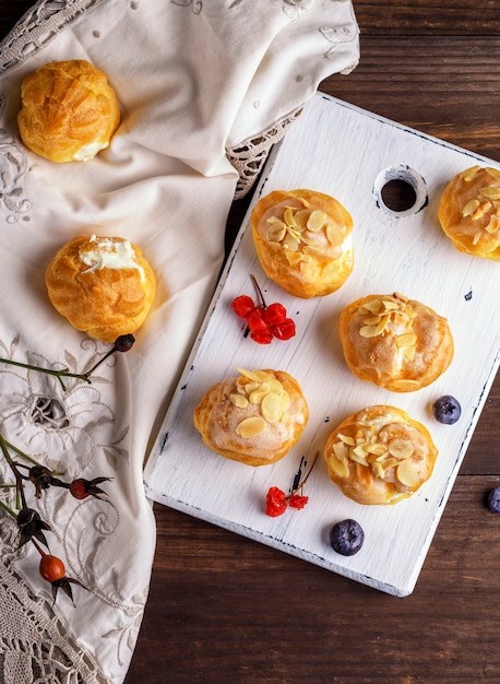 Baked profiteroles with custard sprinkled with almonds 