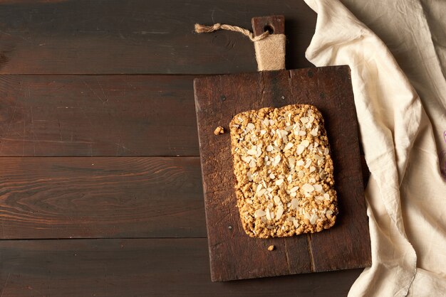 Baked rectangular crumble cake with fruit filling on wooden board