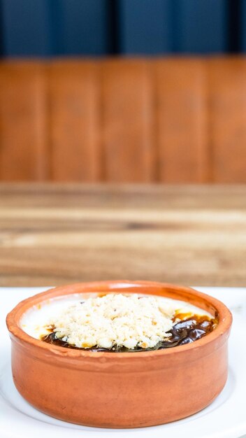 Baked rice pudding decorated with hazelnuts in a clay pot