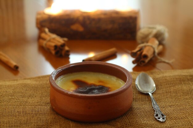 Baked rice pudding turkish dessert sutlac in earthenware casserole with cinnamon sticks