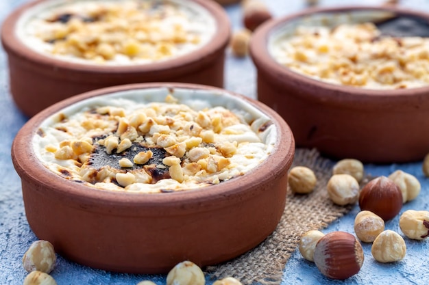 Baked rice pudding turkish milky dessert sutlac in earthenware casserole with hazelnuts