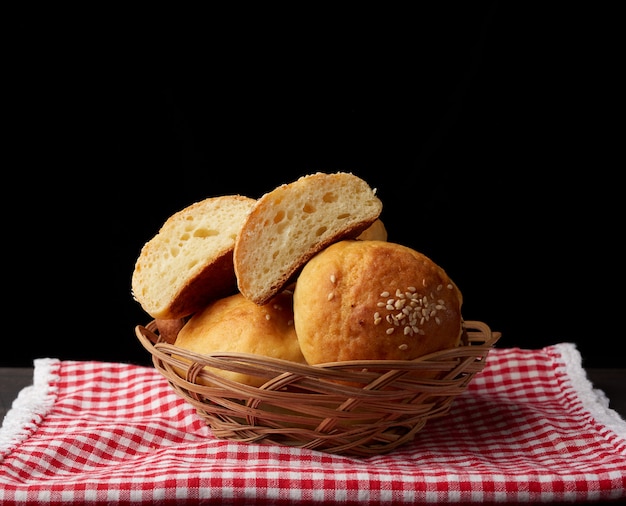 Baked round bun with sesame seeds, black background