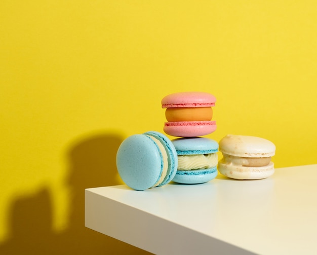Baked round macarons on a yellow background, delicious dessert