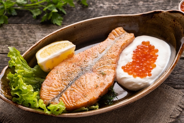 Baked salmon fillet with cream and red caviar. Diet food