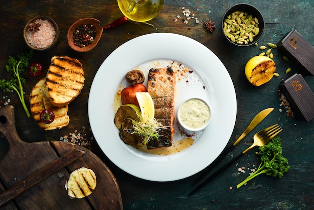 Baked salmon fillet with grilled vegetables on a plate. Top view.