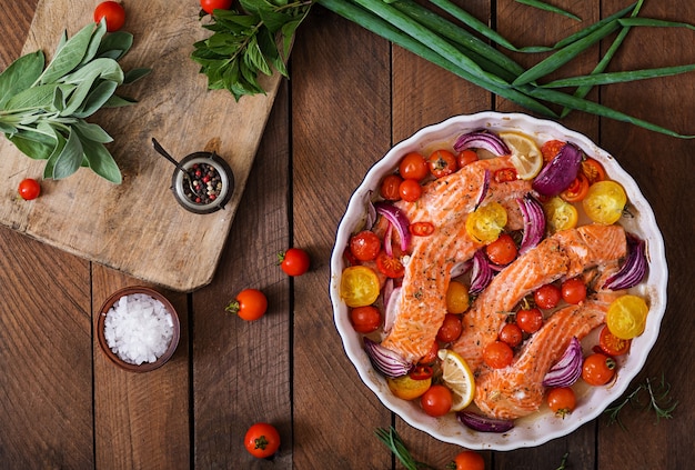 Baked salmon fillet with tomatoes, red onions and spices. Diet menu.