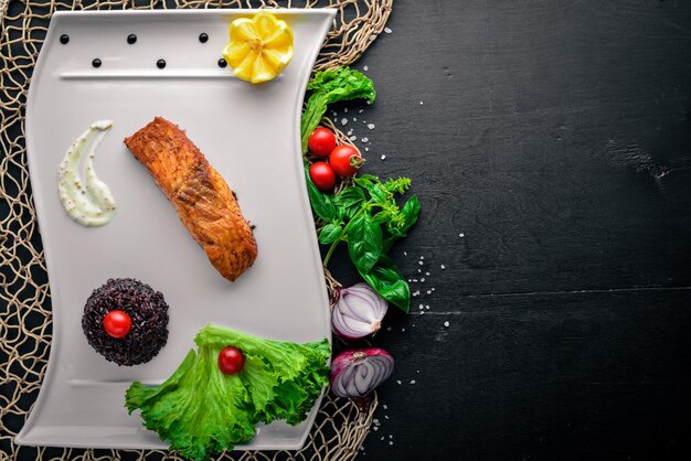 Фото Запеченное филе лосося с диким рисом на деревянном фоне вид сверху свободное место для текста