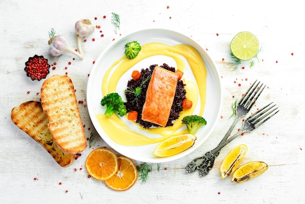 Photo baked salmon fillet with wild rice and vegetables top view free space for text