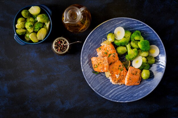 Baked salmon fish garnished with broccoli and Brussels sprouts with leek. Fish menu. Top view.