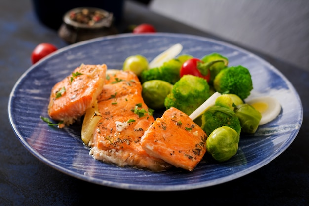 Pesce salmone al forno guarnito con broccoli e cavoletti di bruxelles con porro. menu di pesce.