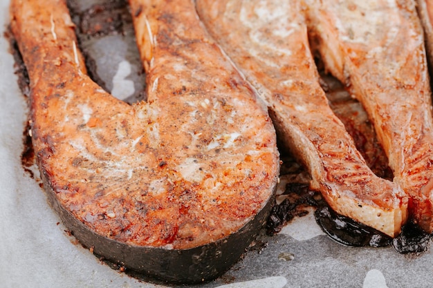 Foto tranci di salmone al forno. il salmone appetitoso succoso si trova sulla teglia. bistecche di pesce fritte rosse