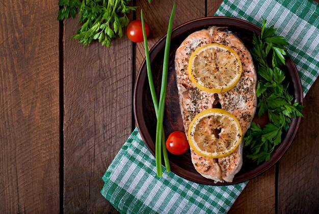 Baked salmon steak with herbs lemon and salad