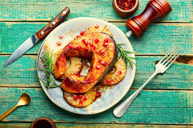 木製のテーブルにパイナップルと焼き鮭ステーキ
