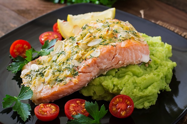 Baked salmon with cheese and almond crust and garnished with mashed potatoes and green peas