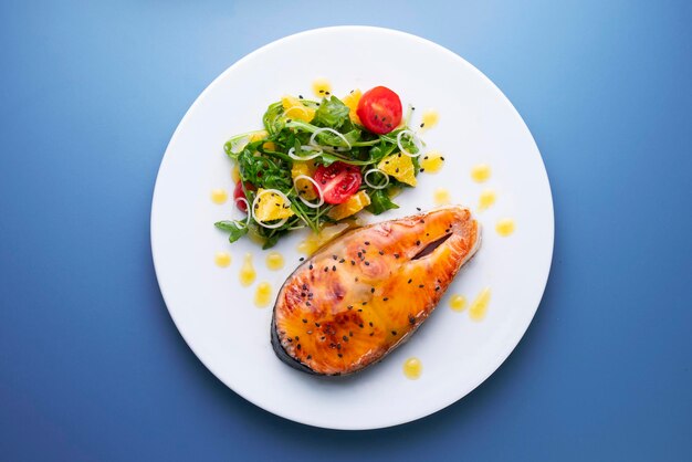 Baked salmon with orange sauce and salad.