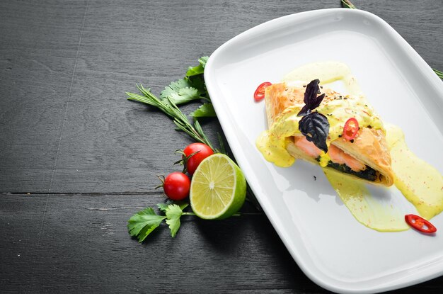 Baked salmon with spinach in dough In the plate Top view Free space for your text