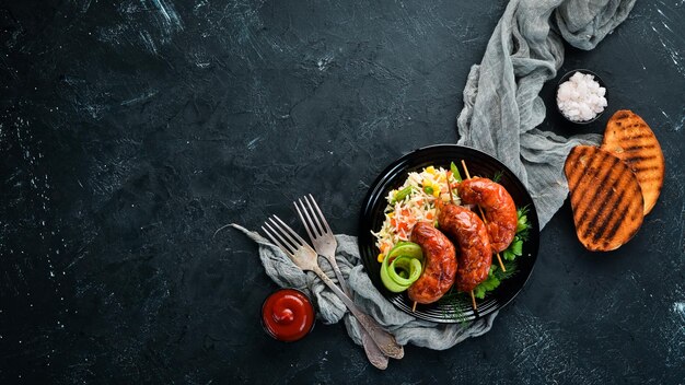 Baked sausages with rice In a black plate Top view Free copy space