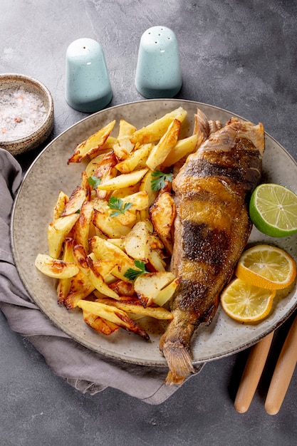 Baked sea bass or lingcod fish with potatoes on a plate on the table